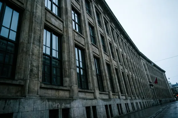 De strenge stenen gevel van een groot instituutsgebouw in koel ochtendlicht